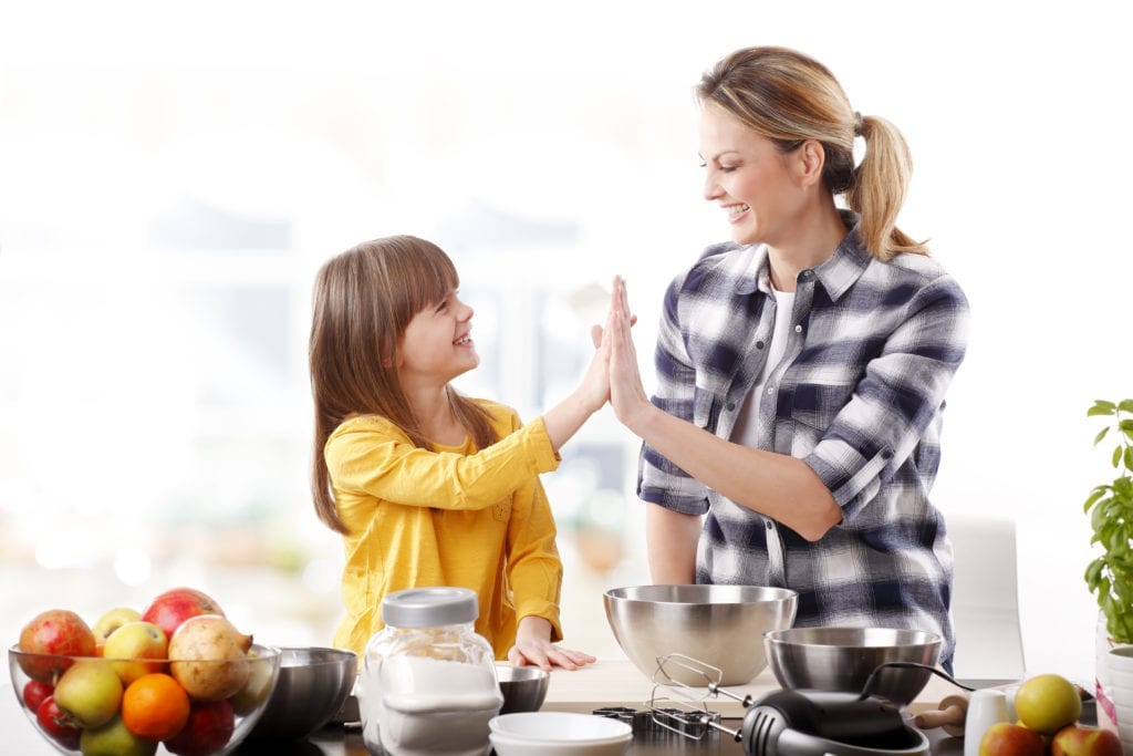 Mother giving high five to daughter